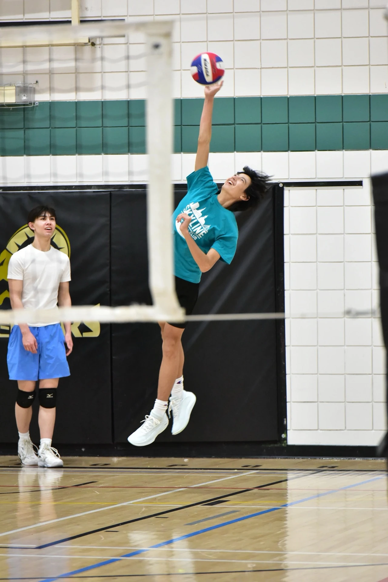 Sky High athlete jumping to hit during training