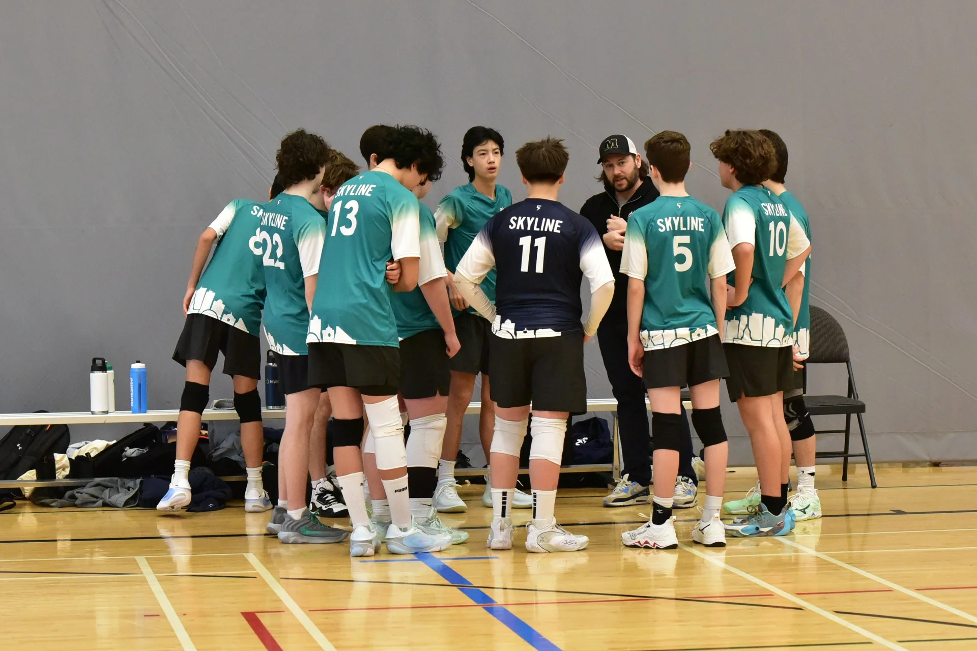 Sky Volleyball head coach leading a team huddle at a tournament